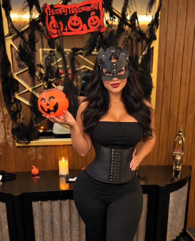 Browns Spa therapist in a cat mask holding a pumpkin lantern